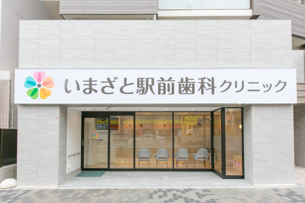 外観の看板に、ロゴマークはカラフルな5色のマークがあり、大きくいまざと駅前歯科クリニックと書かれています。